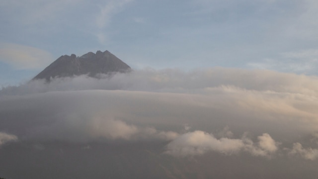 Puncak Gunung Merapi yang diselimuti awan terlihat dari Bronggang, Cangkringan, Sleman, DI Yogyakarta, Kamis (9/7). Foto: Hendra Nurdiyansyah/Antara Foto