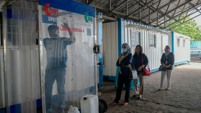 Pegawai berada di dalam bilik disinfektan "Disinfection Chamber" sebelum memulai bekerja di pier 1 Pelabuhan PT Karya Citra Nusantara, Marunda, Jakarta. Foto: Galih Pradipta/ANTARA FOTO