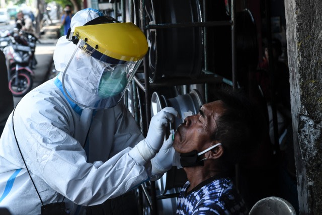 Seorang tenaga medis melakukan tes usap (swab test) kepada pedagang di Jakarta Pusat. Foto: Muhammad Adimaja/Antara