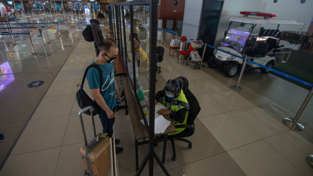 Calon penumpang menyerahkan dokumen hasil tes rapid negatif COVID-19 kepada petugas di Terminal 3 Bandara Soetta, Tangerang. Foto: ADITYA PRADANA PUTRA/ANTARA FOTO