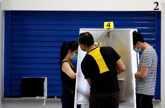 Warga berada dalam bilik pemilihan ketika memberikan suara pada pemilihan umum di Singapura. Foto: Edgar Su/REUTERS