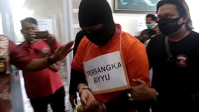 Pelaku saat melakukan reka adegan kasus pembunuhan di RedDoorz Palembang. (foto: istimewa)