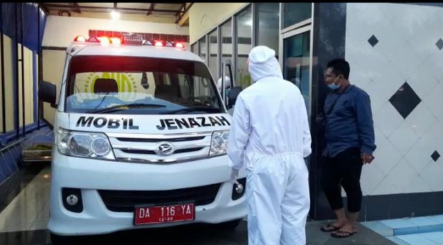 Petugas dari pihak mobil jenazah bersiap-siap membawa pasien terkonfirmasi COVID-19 ke Kalimantan Selatan. | Foto: Karja/Titiantoro