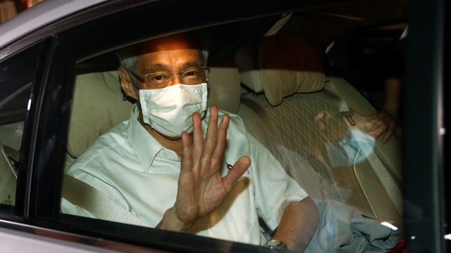 Perdana Menteri Singapura Lee Hsien Loong melambai dari mobil ketika ia meninggalkan kantor Partai Aksi Rakyat di Singapura. Foto: EDGAR SU/REUTERS