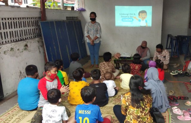 Aan Munandar, mahasiswa Universitas Pembangunan Nasional ‘Veteran’ Yogyakarta (UPNVY), saat memberikan edukasi soal pencegahan COVID-19. Foto: dok. UPNVY.