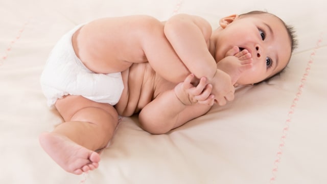 Ilustrasi bayi memasukkan kaki ke mulut. Foto: Shutter Stock