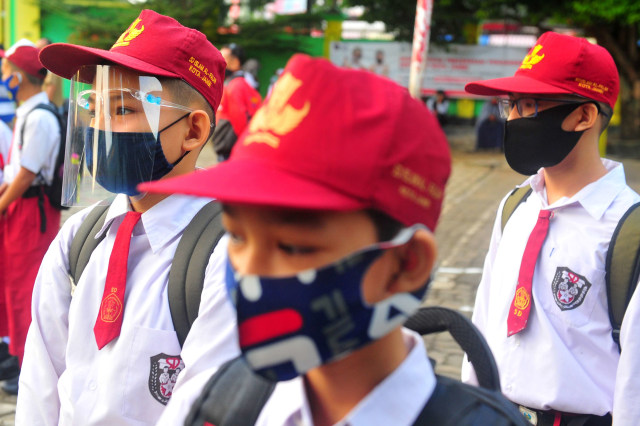 Siswa kelas VII SMPN 1 Kota Jambi mengenakan masker dan pelindung wajah sebelum memasuki kelas pada hari pertama sekolah Tahun Pelajaran 2020/2021 di Jambi. Foto: Wahdi Septiawan/ANTARA FOTO