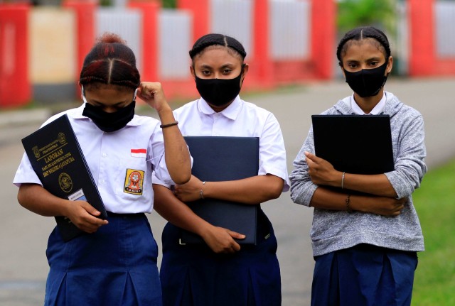 Siswa SMP Negeri 6 Jayapura dengan masker di wajahnya berjalan meninggalkan sekolah usai melakukan pendaftaran ulang pada hari pertama sekolah di Jayapura. Foto: Gusti Tanati/ANTARA FOTO