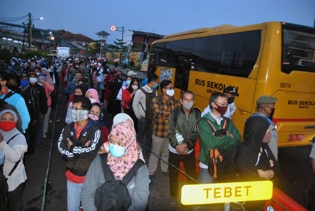 Calon penumpang antre untuk naik bus bantuan gratis di jalan Mayor Oking, Kota Bogor, Jawa Barat, Senin (13/7). Foto: Arif Firmansyah/ANTARA FOTO