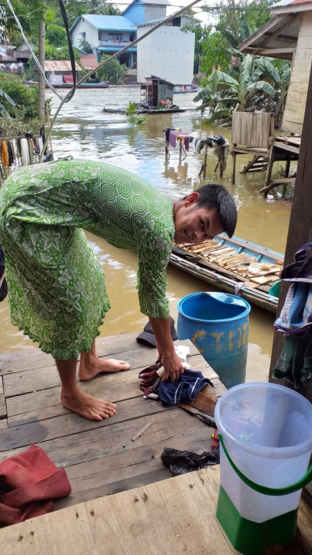 Ahmad Afrizal, warga Desa Nanga Tebidah, Kecamatan Kayan Hulu, terpaksa menggunakan daster ibunya karena semua pakaian basah terendam banjir. Foto: Istimewa