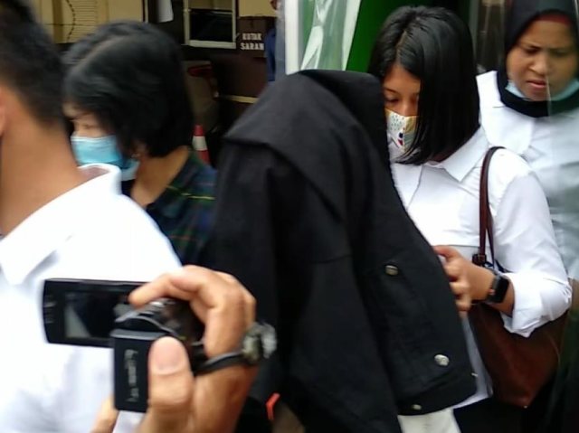  Sosok HH menutupi wajahnya dengan jaket hitam saat menjalani pemeriksaan di Mapolrestabes Medan. Foto: Istimewa