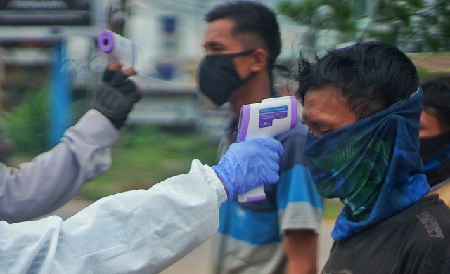 Pemeriksaan suhu tubuh untuk mencegah penyebaran virus corona di Sumsel. (foto: Ary Priyanto/Urban Id)