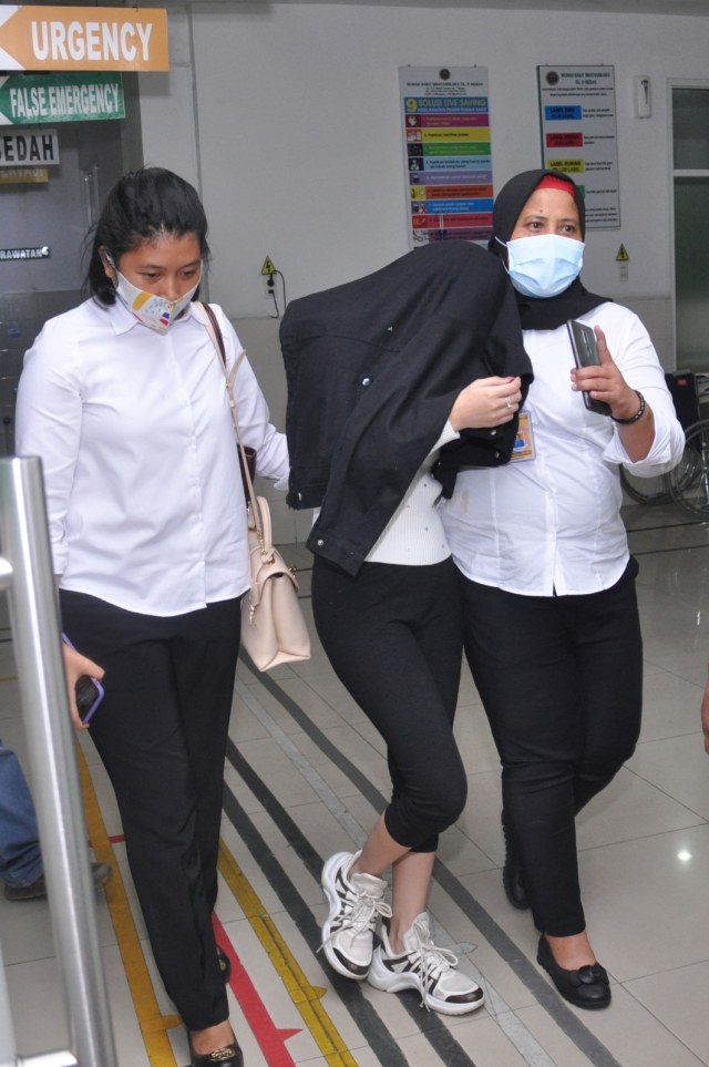 Personel kepolisian membawa artis berinisial HH (tengah) saat menjalani pemeriksaan kesehatan di Rumah Sakit Bhayangkara Polda Sumut, Medan, Sumatera Utara. Foto: Septianda Perdana/Antara Foto