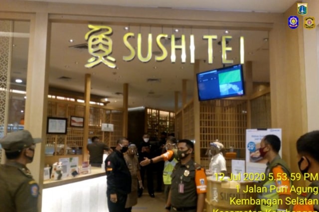 Satpol PP Jakarta Barat menindak Sushi Tei yang tidak membatasi jumlah pengunjung pada masa PSBB di Puri Indah Mall, Minggu (12/7) Foto: ANTARA/HO-Satpol PP Jakarta Barat