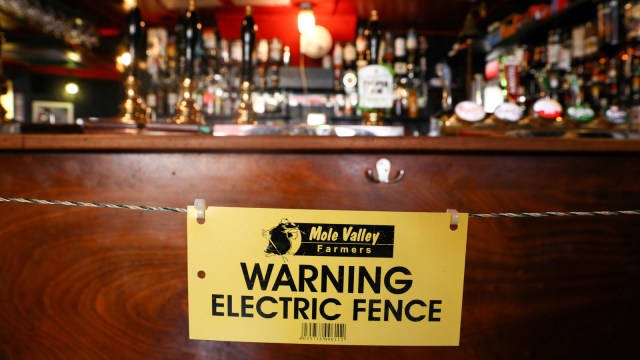 Peringatan pagar listrik di sebuah bar di Inggris yang bertujuan untuk menerapkan jaga jarak fisik. Foto: Tom Nicholson/Reuters