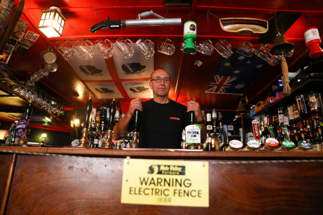Pemilik penginapan Star Inn, Jonny McFadden yang memasang pagar listrik di bar penginapannya di Inggris dengan tujuan menerapkan jaga jarak fisik. Foto: Tom Nicholson/Reuters