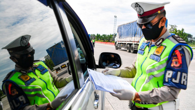 Petugas Polresta Cirebon memeriksa dokumen SIKM dari kendaraan yang melintas di pintu Tol Cipali Palimanan, Cirebon, Jawa Barat, Kamis (21/5).  Foto: ANTARA FOTO/Nova Wahyudi