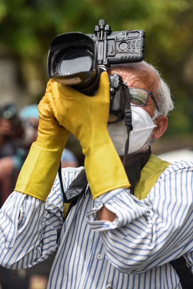 Fotografer mengenakan masker dan sarung tangan saat memotret di tengah lockdown di India. Foto: Prakash Singh/AFP 