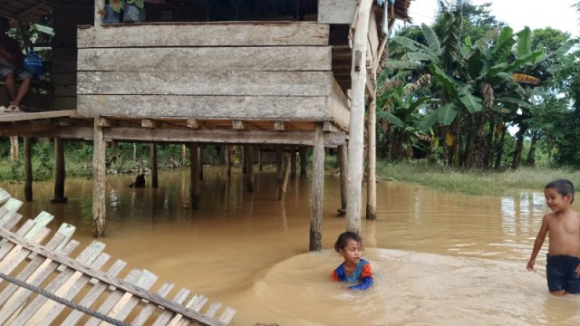 Dua anak sedang bermain di tengah banjir kiriman dari hulu Sungai Maibua, Tolitoli, Sulteng, Jumat (17/7). Foto: Sabran/PaluPoso