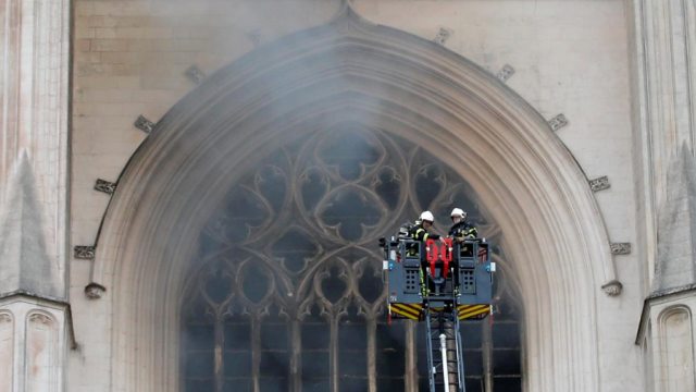 Petugas pemadam kebakaran Prancis saat memadamkan api di Katedral Saint Pierre dan Saint Paul di Nantes, Prancis, Sabtu (18/7). Foto: Stephane Mahe - Reuters
