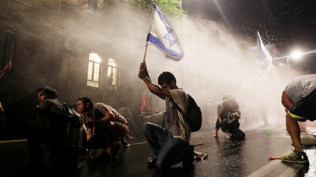 Polisi Israel menembakan meriam air saat membubarkan demonstaan di sekitar kediaman Perdana Menteri Israel Benjamin Netanyahu di Jerusalem, Sabtu (18/7). Foto: Ammar Awad - Reuters