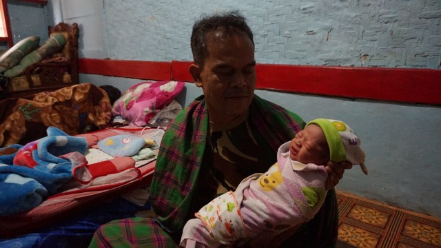 Mahmudin ayah Heni Saat mengendong cucunya di rumah heni kampung Mandalasari, Desa Mamdalasari, Kecamatan Puspahiang, Kabupaten Tasikmalaya, Jawa Barat. Foto: Istimewa