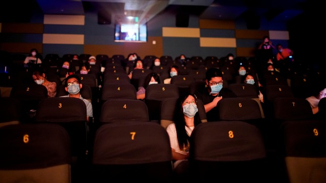 Pengunjung menggunakan masker menonton film di bioskop yang kembali dibuka di Shanghai, China. Foto: Aly Song / REUTERS