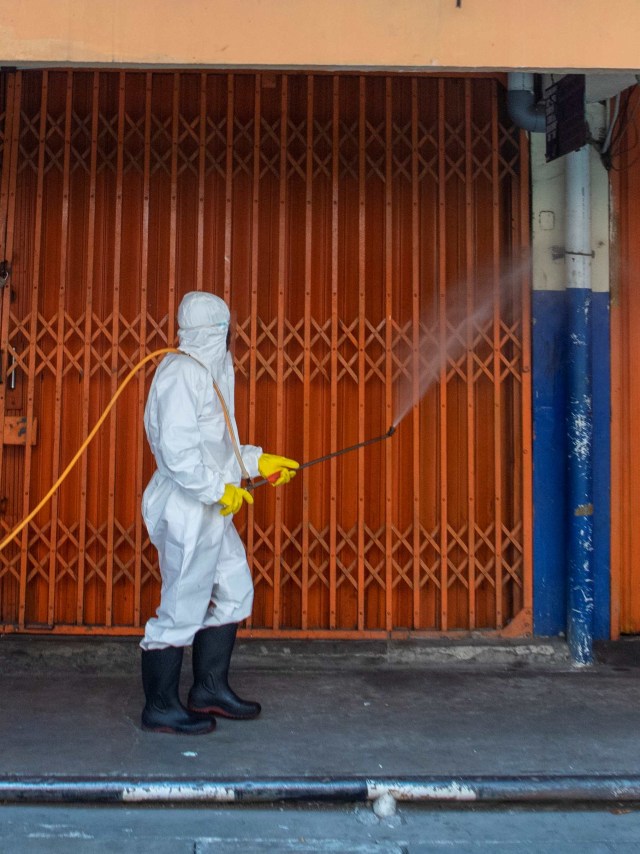 Petugas menyemprotkan cairan disinfektan di area Pasar Asem Reges, Jakarta Barat. Foto: ANTARA FOTO/Nova Wahyudi