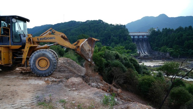 Bulldozer memindahkan tanah roboh di daerah Qingshitan di Yangshuo, China. Foto: THOMAS SUEN/REUTERS