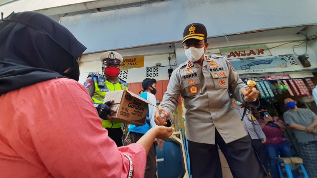 Kapolda Gorontalo, Brogjen Pol Adnas. Membagikan masker dan hand sanitizer pada warga. Rabu, (22/7). Foto: Dok banthayoid (Wawan Akuba)