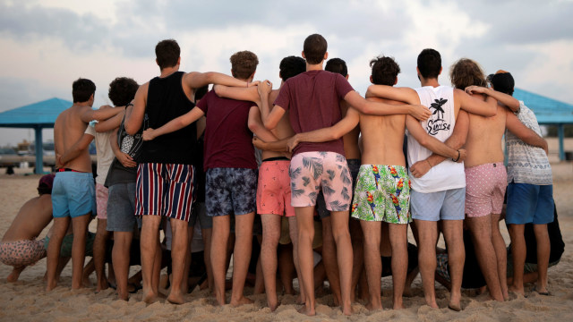 Sejumlah pemuda tampak berkumpul saat mengunjungi pantai Zikim di Israel. Foto: Amir Cohen/REUTERS