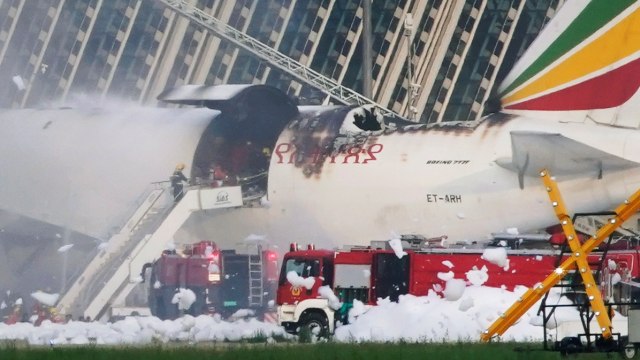 Petugas pemadam kebakaran memadamkan sebuah pesawat kargo Ethiopian Airlines terbakar, di Bandara Internasional Pudong Shanghai di Shanghai, China, (22/7). Foto: Aly Song/REUTERS