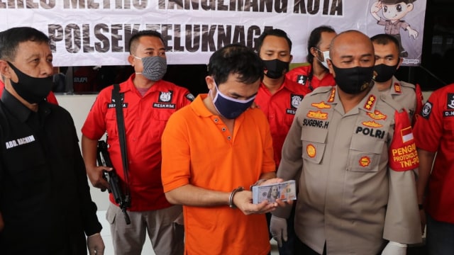 Oknum wartawan yang membuat dolar palsu dihadirkan saat konferensi pers, di Polres Metro Tangerang Kota, Kamis (23/7). Foto: Polres Tangerang Kota
