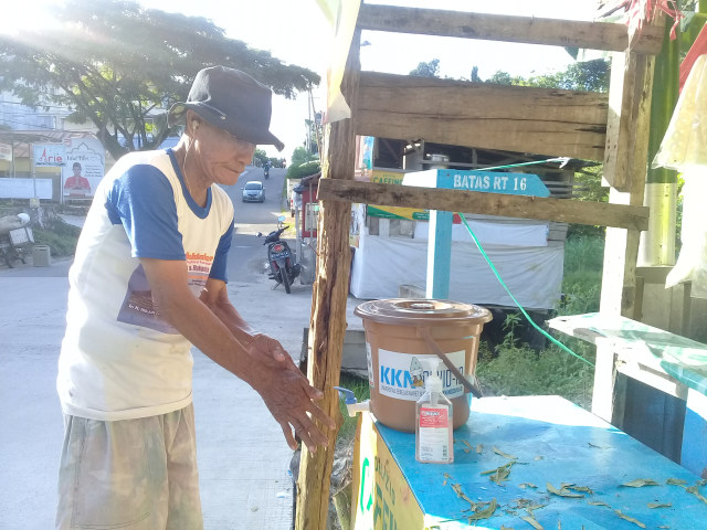 Pengunjung Warung yang sedang Menggunakan Sarana Tempat Cuci Tangan