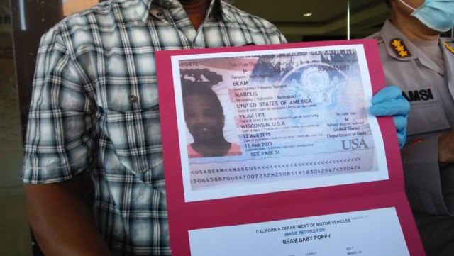Polisi menunjukkan profil Beam Marcus, buronan interpol yang ditangkap di Bali - IST