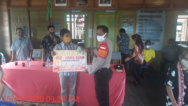 Foto saat Aiptu Sufiani menyerahkan secara simbolis BLT - DD kepada salah satu masyarakat Desa Marawan Lama, Kecamatan Dusun Utara (Dusut), Kabupaten Barsel, Kalteng yang terdampak Covid - 19. 