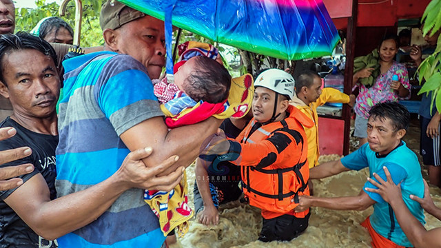 Aksi penyelamatan bayi yang terjebak banjir bandang di Kabupaten Bolsel (foto: dinas kominfo Kabupaten Bolsel)