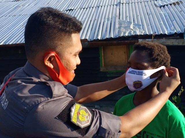 Pemakaian masker kepada masyarakat di Papua. (Dok Polda Papua)