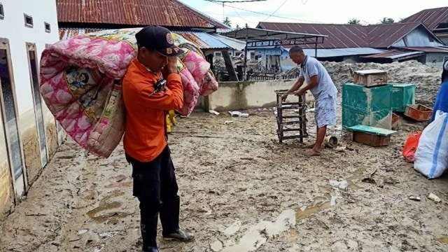 Relawan BPBD Mamuju membantu warga mengevakuasi barang-barang mereka yang tertimbun lumpur. Foto: Dok. Istimewa