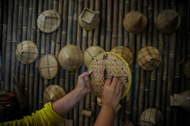 Warga membuat kerajinan jam dinding dari anyaman bambu di Kampung Pangaroan, Desa Cipanas, Tanjung Kerta, Kabupaten Sumedang, Jawa Barat, Sabtu (25/7/2020). Foto: RAISAN AL FARISI/ANTARA FOTO