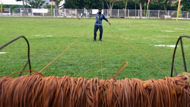 Seorang petugas memasang tali jarak saf di Lapangan Bukit yang jadi salah satu lokasi ibadah shalat pada Hari Raya Idul Adha saat pandemi COVID-19, di Kota Pekanbaru, Riau, Kamis (30/7).  Foto: FB Anggoro/ANTARA FOTO
