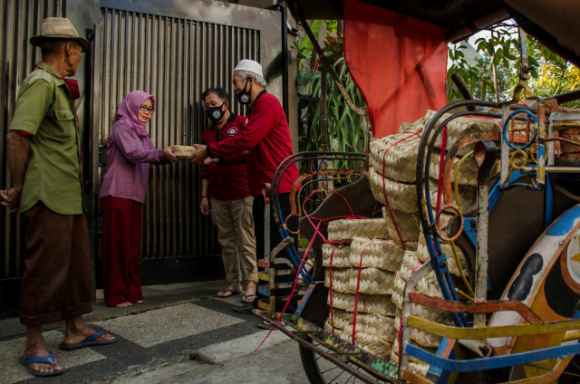 Pengurus Dewan Kemakmuran Masjid (DKM) membagikan daging kurban menggunakan besek (wadah anyaman bambu) kepada warga di kawasan Cihapit, Bandung, Jawa Barat. Foto: Novrian Arbi/Antara Foto