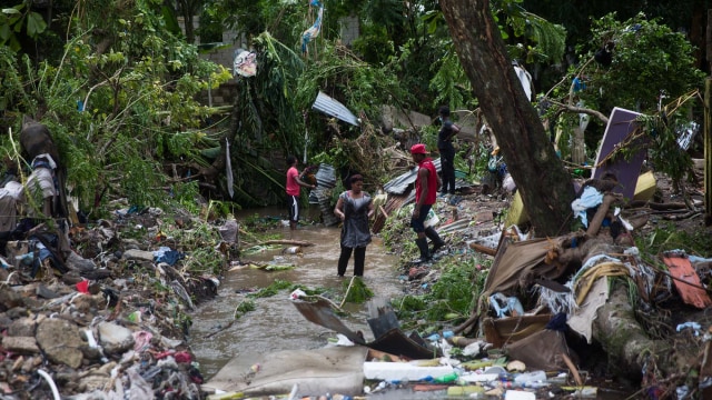 Warga setempat berusaha menyelamatkan milik mereka setelah meluapnya sungai Magua yang disebabkan oleh hujan lebat yang terjadi selama badai Isaias di kota Hato Mayor, Republik Dominika. Foto: ERIKA SANTELICES/AFP