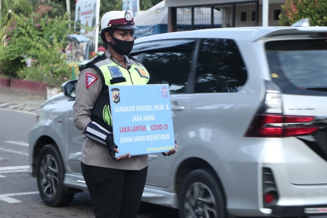 Personel Satuan lalu Lintas Polda Papua saat mengingatkan pengguna jalan mematuhi protokol kesehatan di tengah pandemi. (Dok Polda Papua)