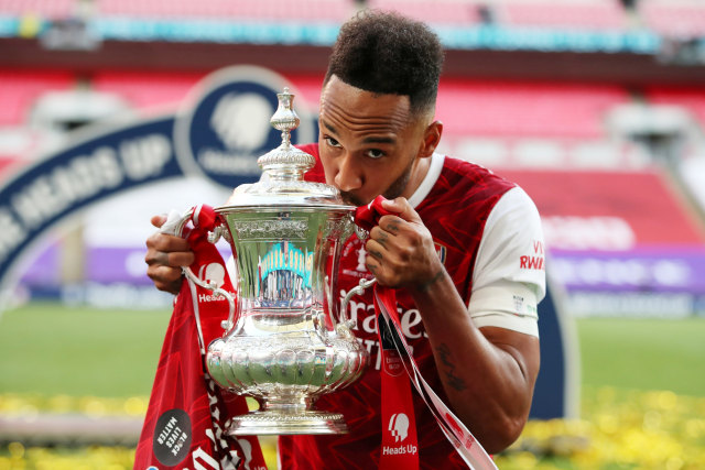 Pemain Arsenal Pierre-Emerick Aubameyang mencium trofi Piala FA yang sebelumnya ia jatuhkan. Memang. Foto: Adam Davy/REUTERS