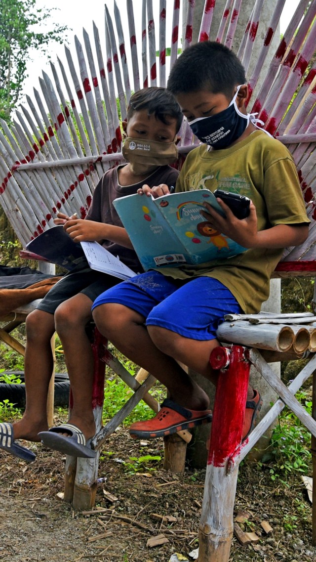 Sejumlah murid SD Negeri Jakung mengikuti proses belajar mengajar secara daring di pos ronda di tepi jalan supaya bisa mendapat sinyal di Kampung Gunungsari, Serang, Banten, Rabu (29/7). Foto: Asep Fathulrahman/ANTARA FOTO