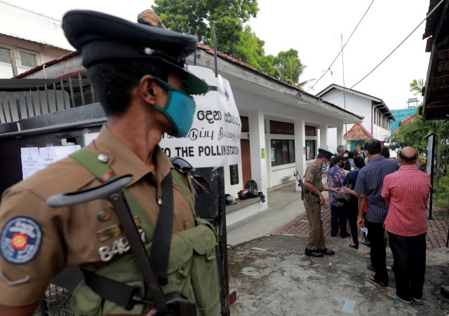 Petugas polisi yang mengenkan masker berja saat warga antre untuk melakukan pemungutan suara di salah satau tempat pemungutan suara di Kolombo, Sri Lanka, Kamis (5/8). Foto: Dinuka Liyanawatte/Reuters