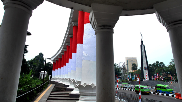 Angkutan kota melintas di depan Tepas Lawang Salapan yang dibalut dengan bendera merah putih di jalan Otto Iskandardinata, Kota Bogor, Jawa Barat, Selasa (4/8). Foto: Arif Firmansyah/ANTARA FOTO