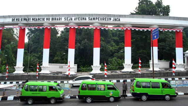 Angkutan Kota berada di depan Tepas Lawang Salapan yang dibalut dengan bendera merah putih di jalan Otto Iskandardinata, Kota Bogor, Jawa Barat, Selasa (4/8). Foto: Arif Firmansyah/ANTARA FOTO