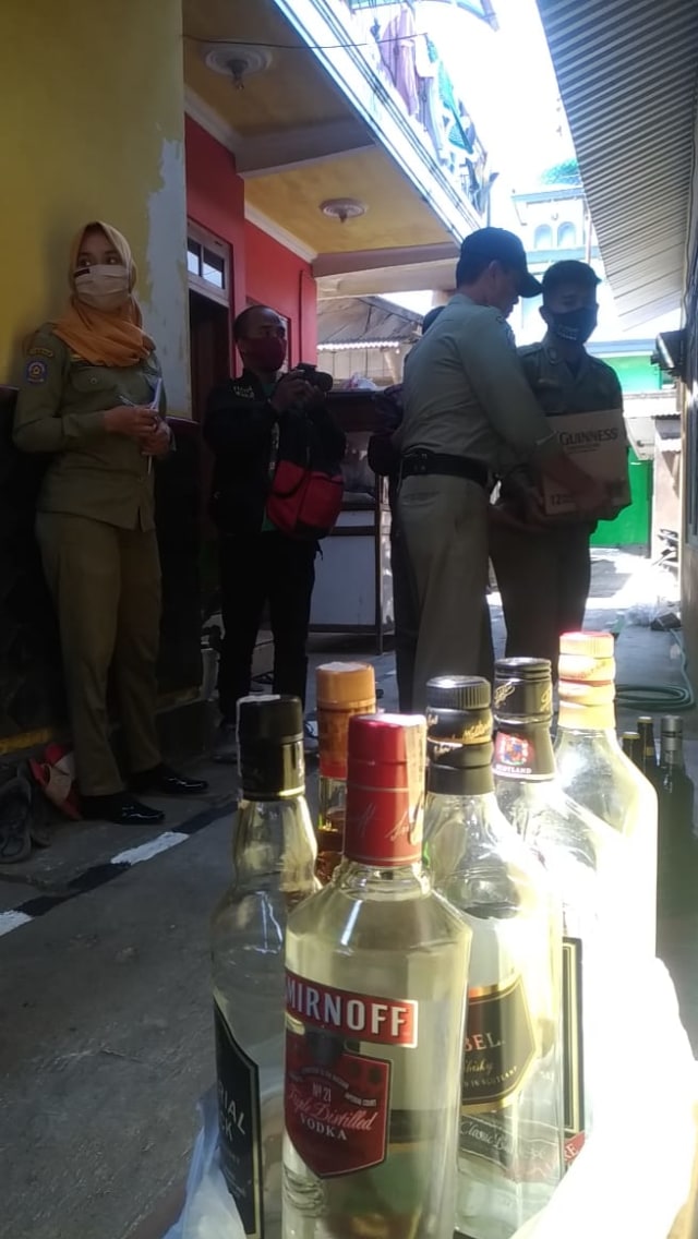 Petugas dari Satpol PP Temanggung mengamankan barang bukti minuman keras saat pengrebekan di Kampung Jampirejo, Kecamatan Temanggung, Jateng, Kamis (6/8/2020). Foto: ari/Tugu Jogja